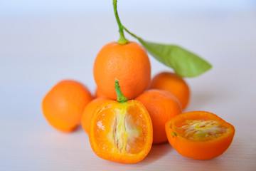 Calamondins on white cutting board