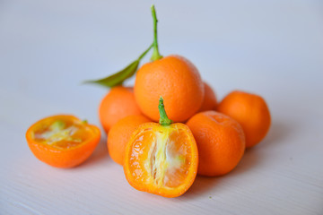 Calamondins on white cutting board