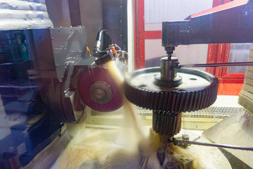 Abrasive stone produces a high-precision gear grinding of a gear wheel on a CNC machine, oil as a coolant.