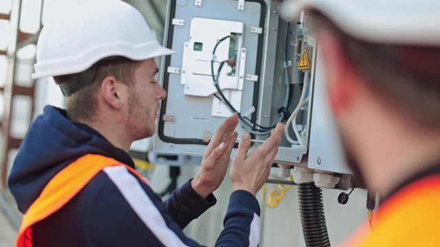 Man working at solar power station. Electrical engineer repairing electricity box at solar power plant
