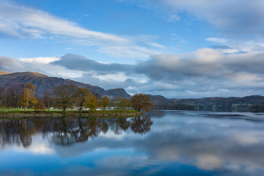 Breathtaking vibrant aerial drone landscape images over Coniston Water at sunrise on beautiful Autumn Fall morning