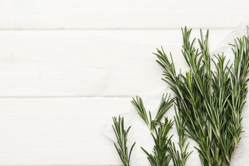 Flat lay composition with fresh rosemary on wooden background, space for text