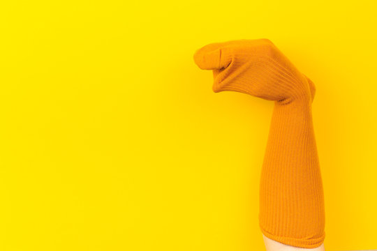 funny doll sock on yelow background, hand theater - Image