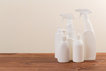 Cleaning product plastic container for house clean on wooden table and gray background . household chemicals