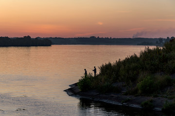Twilight on the river. Landscape. Fishermen on the coast.