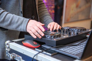 Hands of a DJ playing at an away event