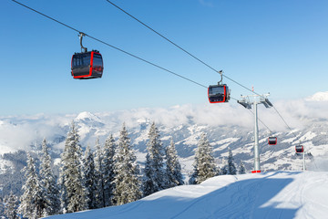Modern ski gondola in an Austrian ski resort on a snowy winter day. - obrazy, fototapety, plakaty