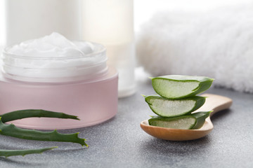 Obraz na płótnie Canvas Aloe vera sliced leaves and natural cream, lotion, tonic and towel on white background
