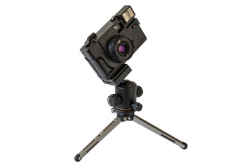 Old film photo camera on a mini tripod