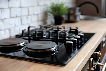 Obraz premium New modern stove with gas and electric burners in kitchen