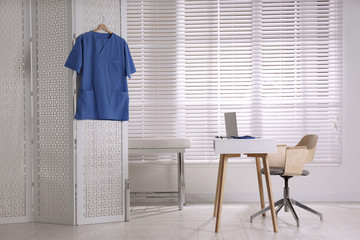 Doctor's office interior with desk and examination couch