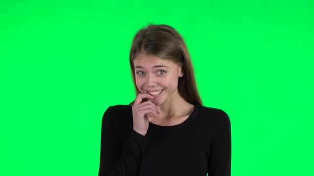 Young woman throwing up hands expressing she is innocent, saying oops she doesn't know what's going. Green screen