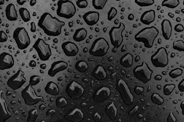 black drops of water on a dark surface