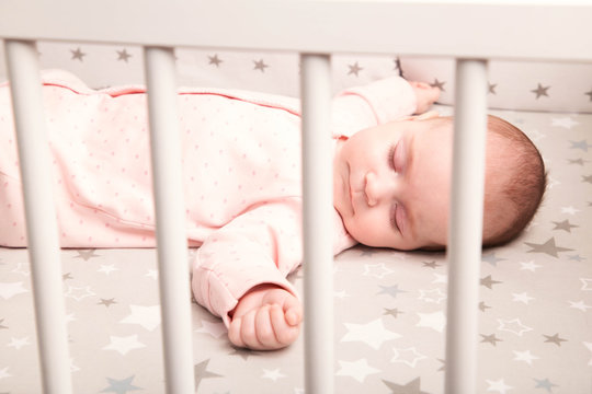 Cute Baby Sleeping In A White Crib