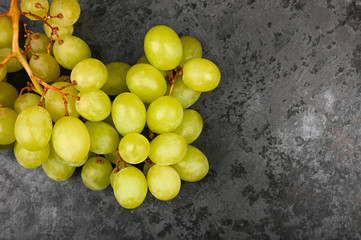 Photo of green grape on a marble dark background. Volumetric grapes. A bunch of green grape bush.