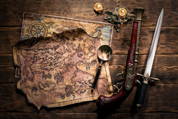 Pirate treasure map on brown wooden table flat lay background.