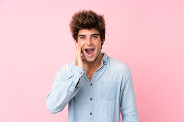 Fototapeta na wymiar Young caucasian man with jean shirt over isolated pink background with surprise and shocked facial expression