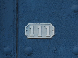 Vintage grunge square metal rusty plate of number of street address with number. Close up, brand.