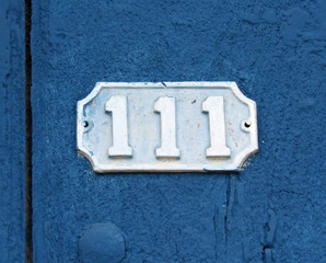Vintage grunge square metal rusty plate of number of street address with number. Close up, brand.