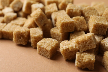Many sugar cubes on craft background, close up