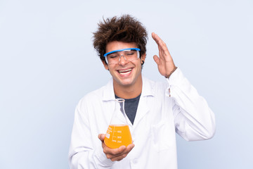 Young scientific man over isolated blue background laughing