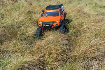 View of radio controlled model  racing car on off-road background. Toys with remote control. Free time. Children and adults concept.