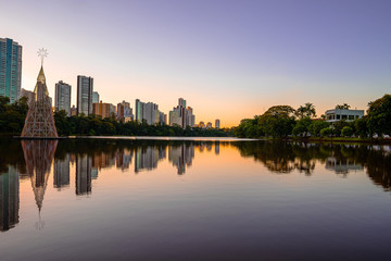 Fototapeta na wymiar Beautiful sunset at Igapo lake, Londrina PR Brazil. Water of the lake and buildings of the city on the photo.