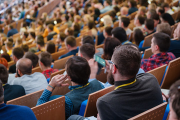 Business conference attendees sit and listen