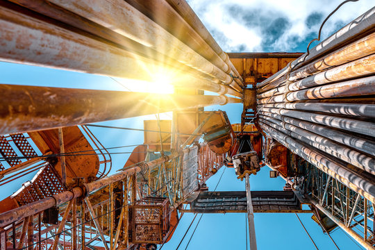 Oil and Gas Drilling Rig onshore dessert with dramatic cloudscape. Oil drilling rig operation on the oil platform in oil and gas industry