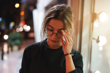 Modern pretty woman in glasses, city lights. Close up portrait in night city