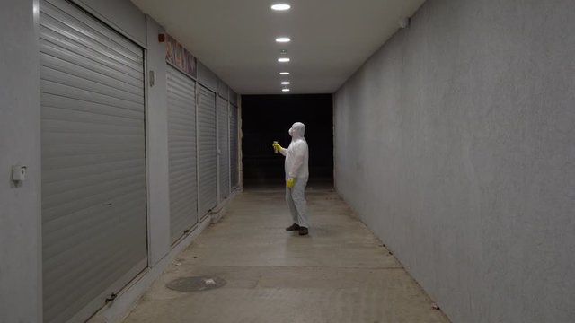 man in bio hazard protective suit with respirator mask and gloves walks in a uninhabited corridor with a respirator in his hand and treats infection.  Novel coronavirus - 2019-nCoV, WUHAN virus concep