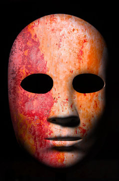 Textured mask with cracked rough wood  painted surface, neutral expression on dark background.