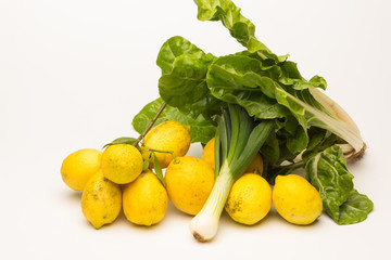 Yellow lemons and fresh green vegetables