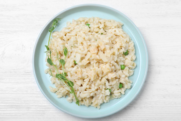Delicious risotto with cheese on white wooden table, top view