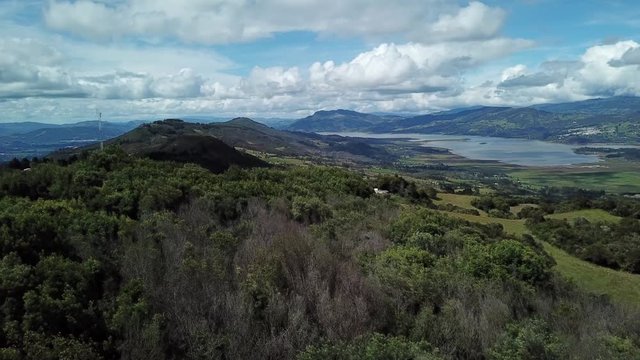 Aerial shot of a beautiful landscape of a lake, surrounded by huge mountains, on a sunny day in Cundinamarca, Colombia. Tomine and guatavita dam. 4k drone.