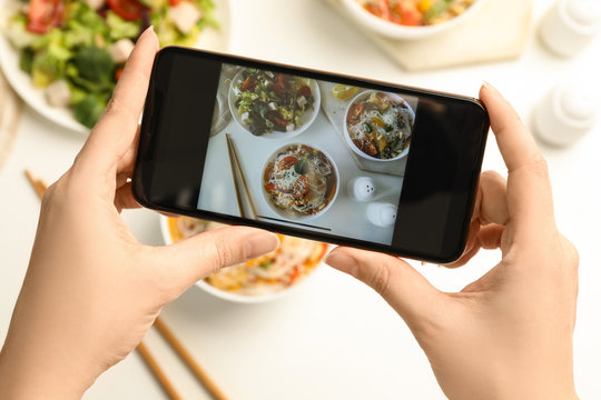 Blogger taking picture of lunch at table, top view