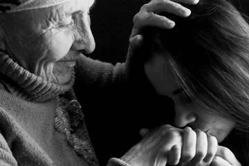Respect for daughter to her grandmother. A young girl respects an old grandmother. Black and white...