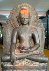 Bas-relief of a seated Buddha in a lotus position made of stone.