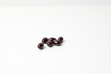 Group of astaxanthin capsules scattered on a white background.