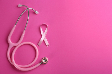 Obraz na płótnie Canvas Pink ribbon and stethoscope on color background, flat lay with space for text. Breast cancer concept