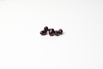 Group of astaxanthin capsules scattered on a white background.
