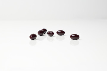 Astaxanthin capsules scattered on a white background.