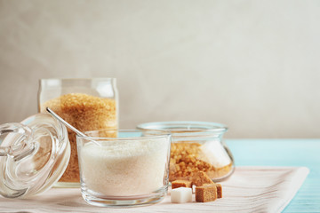 Various bowls with sugar on light blue wooden table
