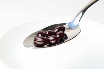 Astaxanthin in the spoon on a white background. Close-up