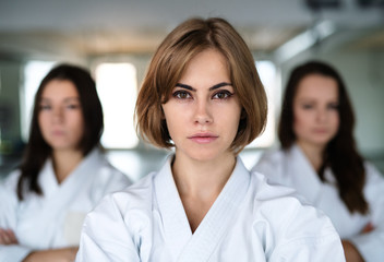 Group of young women practising karate indoors in gym. © Halfpoint