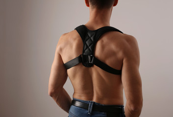 Attractive muscular man with posture corrector. Scoliosis, Kyphosis treatment