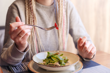 Portrait of caucasian hipster vegan woman eating in restaurant. Healthy eating concept