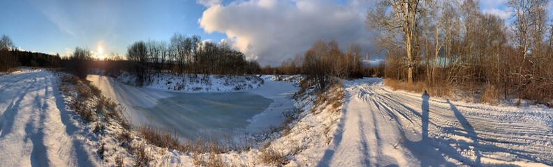 Panoramic view with winter river and snow forest. Beautiful winter landscape