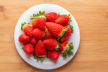 strawberries in a bowl on wooden table