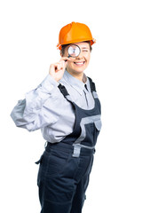 girl construction engineer examines something in a magnifying glass. Isolated